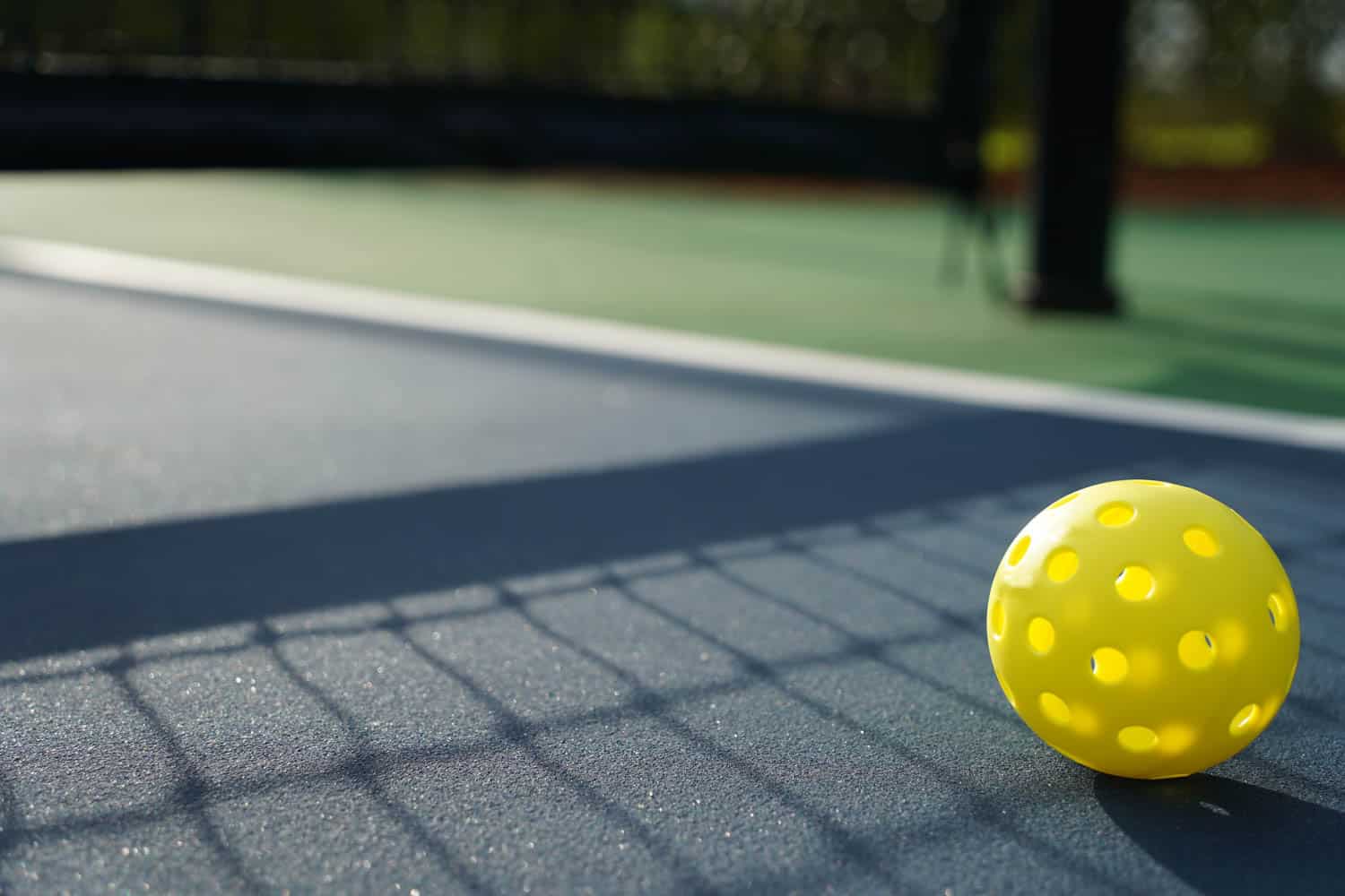 Close up of a pickleball on pickleball court.