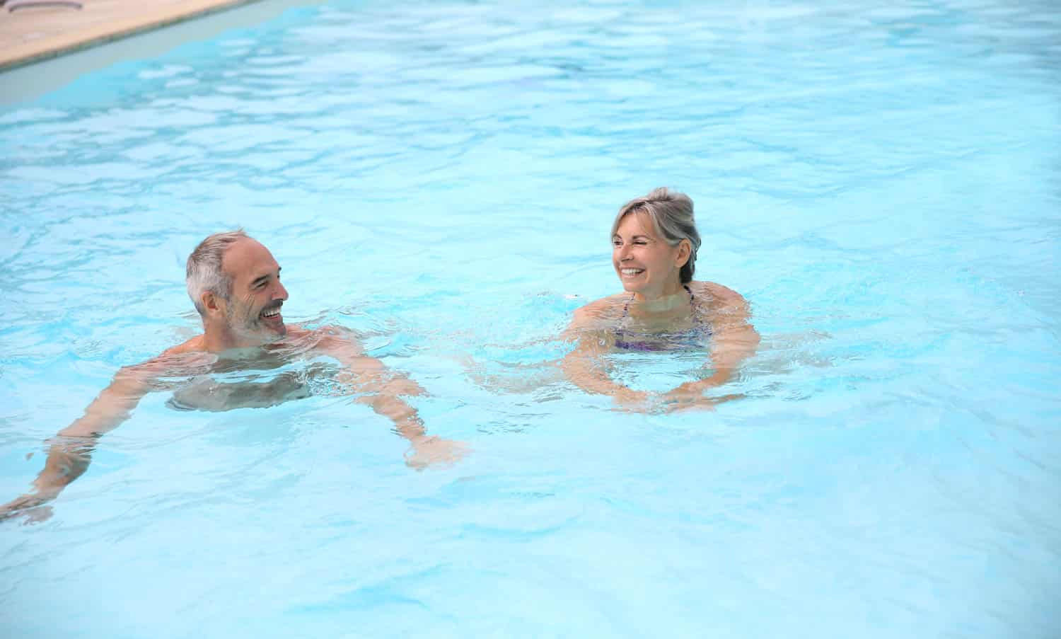 Active senior couple in resort pool